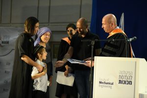 Dean of the Faculty of Mechanical Engineering Prof. Alon Wolf and Prof. Shmuel Osovski presenting the MSc degree in Mechanical Engineering to Shaked, the widow of the late Chief Sergeant Dovi Kogan, his son, and his mother Chaya at the ceremony. (Photo credit: Dor Aharon)